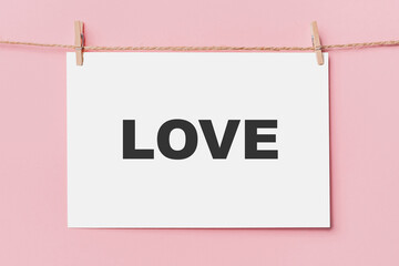 note letter pin on rope on pink background, love and valentine concept