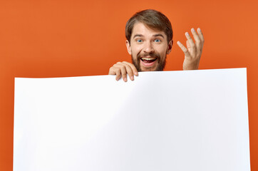 guy with white paper on orange background Poster mockup advertising sign