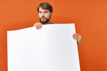 guy with white paper on orange background Poster mockup advertising sign