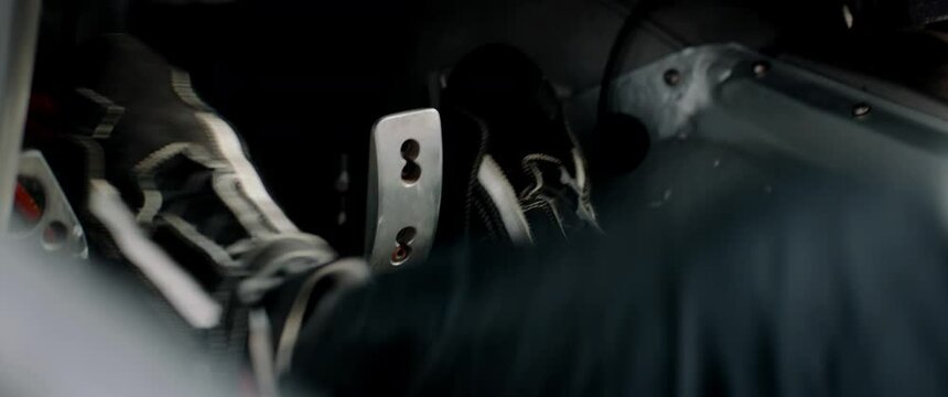 CU view of driver's legs pressing on pedals while racing inside a sports car. Shot with 2x anamorphic lens