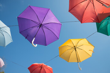 Colorful umbrella decoration in day market festival in city park with blue sky background. Outdoor summer festival concept.