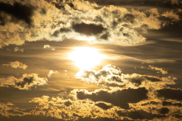 Obraz premium Closeup of the sun setting behind some clouds