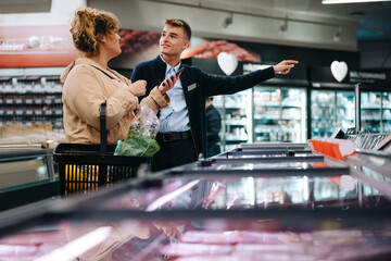 Trainee directing shopper to an aisle