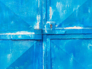 Metal door with weathered blue paint and security insert lock.