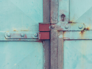 Massive steel door latch with armored padlock. Metal obsolet door