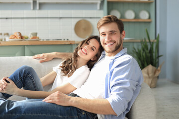 Portrait of cute young couple sitting in sofa.