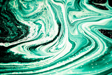 Selective focus. Green malachite creative abstract painted background, wallpaper, acrylic painting on canvas. Texture art. Blue paint with gold glitter powder. Marble background.