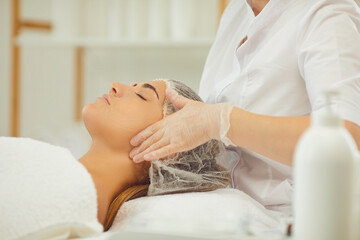 Fototapeta na wymiar Hands of massuer making lifting facial massage for young woman