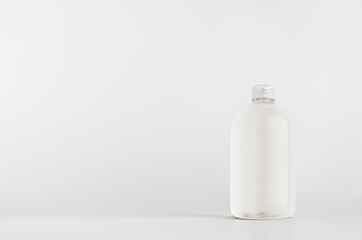 Transparent plastic low thick bottle with water or cosmetic product with silver cap mockup on white background, template, copy space.