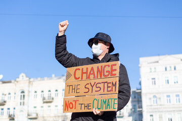 Solo picket protest in city square save the planet concept with slogan Change the System not the...