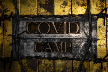 Covid Camp text formed with real authentic typeset letters on vintage textured silver grunge copper and gold background