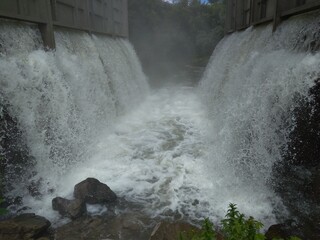 water flows down the waterfall in the basement of the dam flood accident