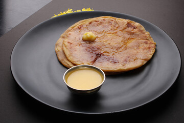 Puran Poli, also known as Holige, is an Indian sweet flatbread from India consumed mostly during Holi festival. Served in a plate with pure Ghee.