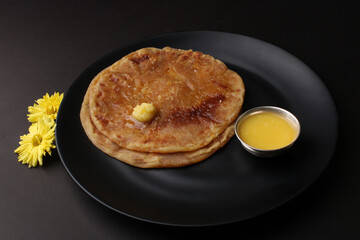 Puran Poli, also known as Holige, is an Indian sweet flatbread from India consumed mostly during Holi festival. Served in a plate with pure Ghee.