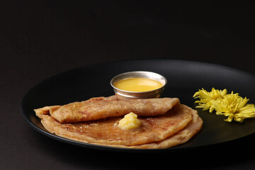 Puran Poli, also known as Holige, is an Indian sweet flatbread from India consumed mostly during Holi festival. Served in a plate with pure Ghee.
