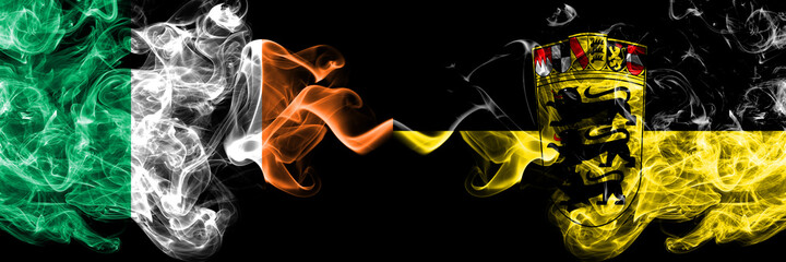 Republic of Ireland, Irish vs Germany, German, Deutschland, Baden Wurttemberg smoky mystic flags placed side by side. Thick colored silky abstract smoke flags.