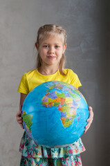 A girl holds a globe in her hand