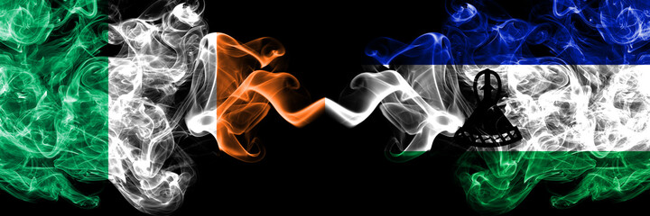 Republic of Ireland, Irish vs Lesotho smoky mystic flags placed side by side. Thick colored silky abstract smoke flags.