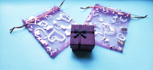 Purple gift box with two festive bags with hearts. Top view perspective.