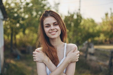 happy woman gesturing with hands outdoors in garden summer trees vacation