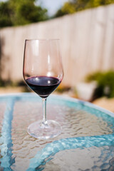 glass of red wine on top of cafe table in al fresco garden