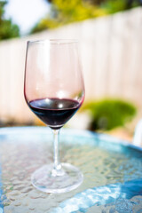 glass of red wine on top of cafe table in al fresco garden