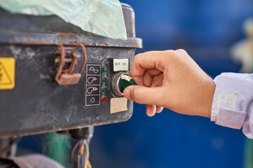 Switch on-off and worker hand to operate machine in industrial