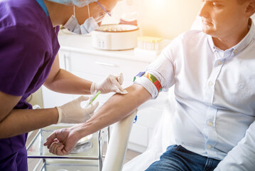 Nurse taking a patient's blood sample at lab