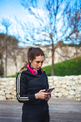 Portrait of a sporty young woman with headphones while exercising outdoors. 