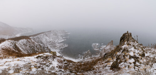 Snow storm over sharp sea cliffs
