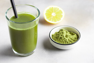 healthy detox drink with green superfood powder in glass. plant-based caffeine drink. herbal...