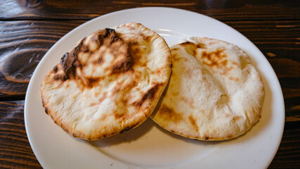 Two small bread tortillas stand in a plate on the table