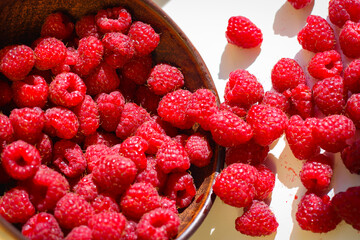 Red ripe and juicy raspberry in an inverted small bowl
