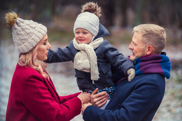 young family walking in the park in winter