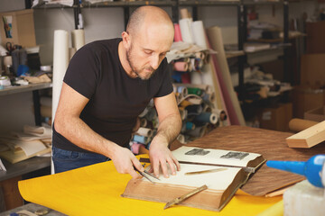book binder restores old book in craft workshop