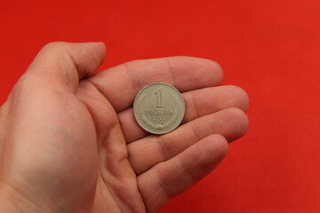 The soviet coin ruble in hand on red background