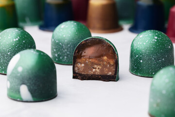 Chocolate candies dome-shaped with salted caramel cream and ginger crumble ganache