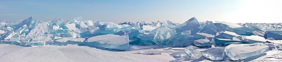  A panorama of the edge of a hummock field with beautiful huge blocks of transparent blue ice on the frozen Lake Baikal on a sunny frosty day. Cool natural background. Unusual winter landscape © Katvic