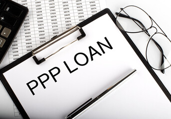 PPP LOAN text with calculator, glasses and pen on chart background