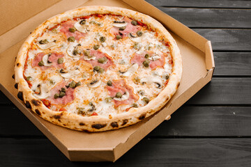 Tasty fresh pizza with ingredients on wooden background