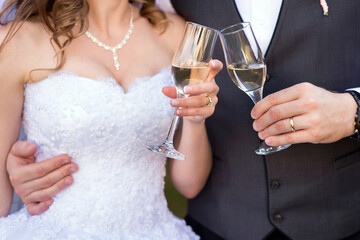 two glasses of champagne in the hands of the bride and groom
