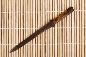Old military weapon bayonet isolated on wooden background