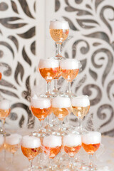 Cocktail pyramid with glasses of champagne at the wedding