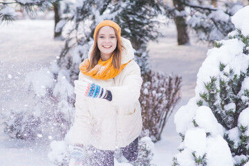 Fototapeta premium Portrait of a happy smiling girl on a snowy winter day