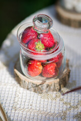 Fresh strawberries, in a glass jar on the table