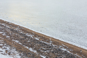 Frozen lake shore and snow