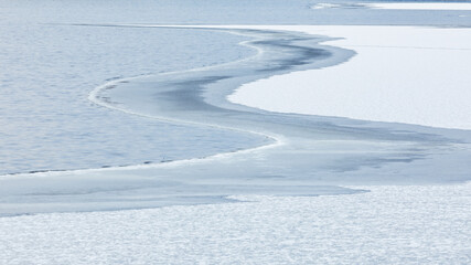 Partially frozen lake surface and snow