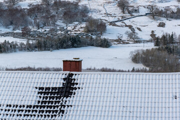 Fresh white snow cover on roof top of house and chimney,background white sky, beautiful winter...