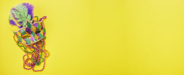 Mardi gras or carnival mask with beads on yellow background. Venetian mask. © vetre