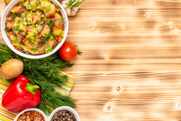 French tartiflette with reblochon cheese and bacon on a wooden background with salad. Copy space. Top view.